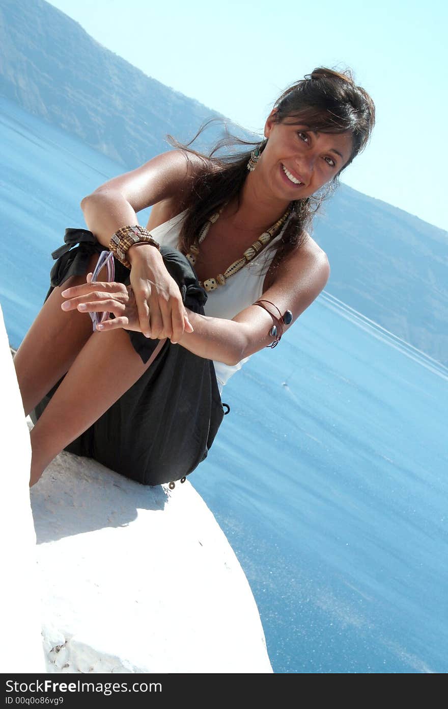 Cute girl above the roof in Oia Santorini Greece / Woman Pose. Cute girl above the roof in Oia Santorini Greece / Woman Pose