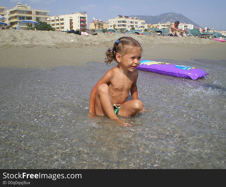 The happy girl on sea beach. Play in water. The happy girl on sea beach. Play in water.