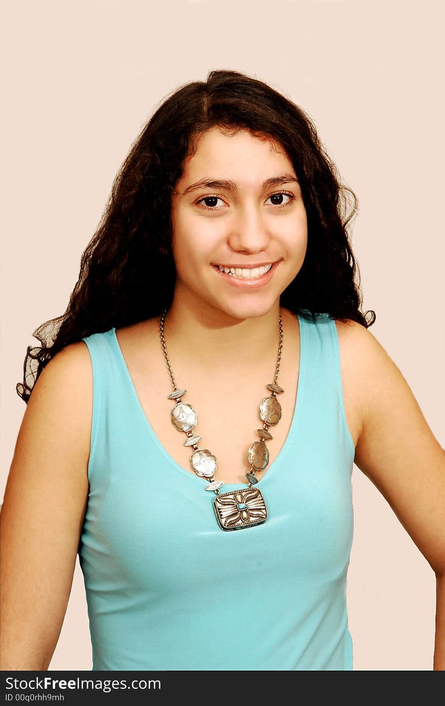 A young girl in jeans and turquoise sweater sitting for a portrait. A young girl in jeans and turquoise sweater sitting for a portrait.