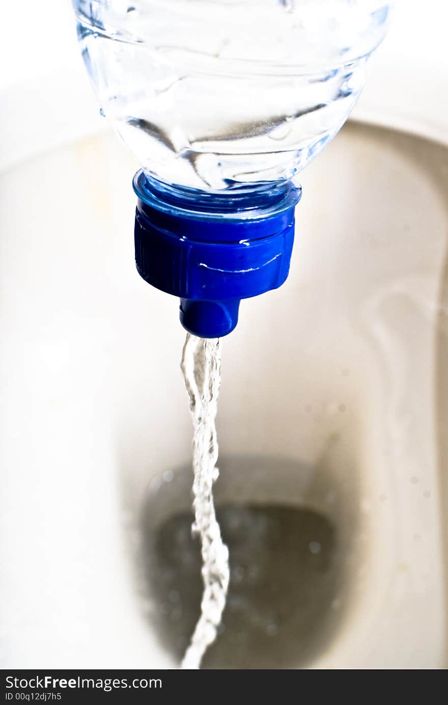 Wasting Water flowing from a flexible plastic bottle