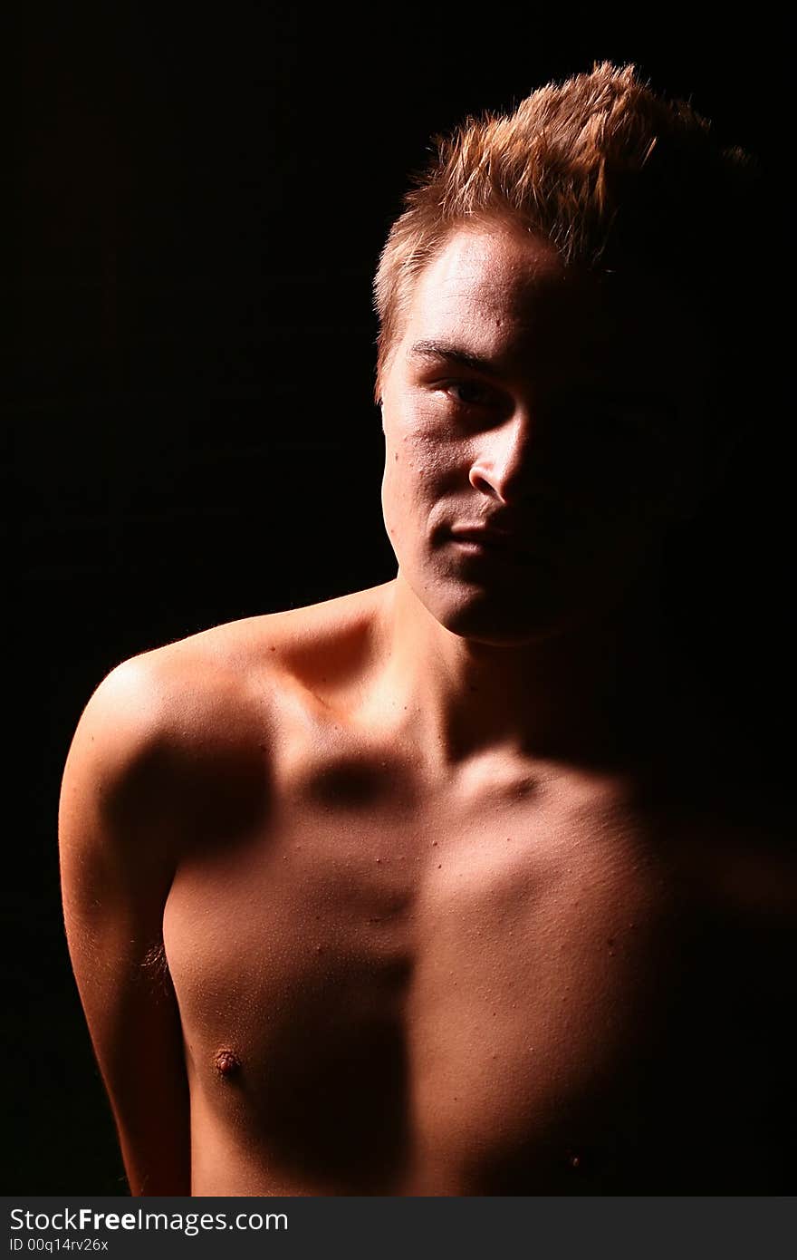 Profile of a young muscular man staring into the camera in color