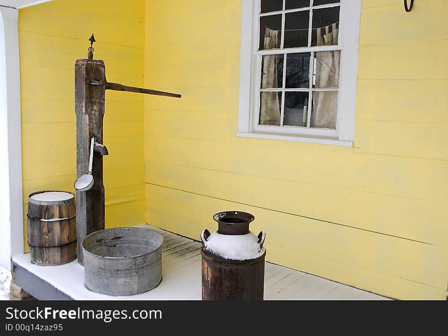 Typical homestead from 19th century farm and small town. Hand water pump and porch artifacts date the scene. Simple and tranquil scene. Typical homestead from 19th century farm and small town. Hand water pump and porch artifacts date the scene. Simple and tranquil scene.