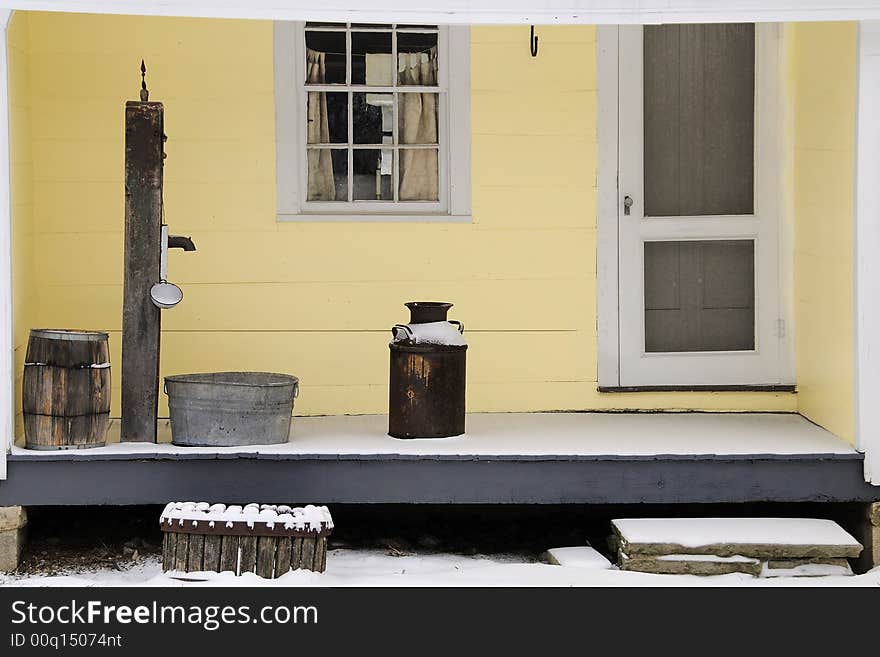 Typical homestead from 19th century farm and small town. Hand water pump and porch artifacts date the scene. Simple and tranquil scene. Typical homestead from 19th century farm and small town. Hand water pump and porch artifacts date the scene. Simple and tranquil scene.