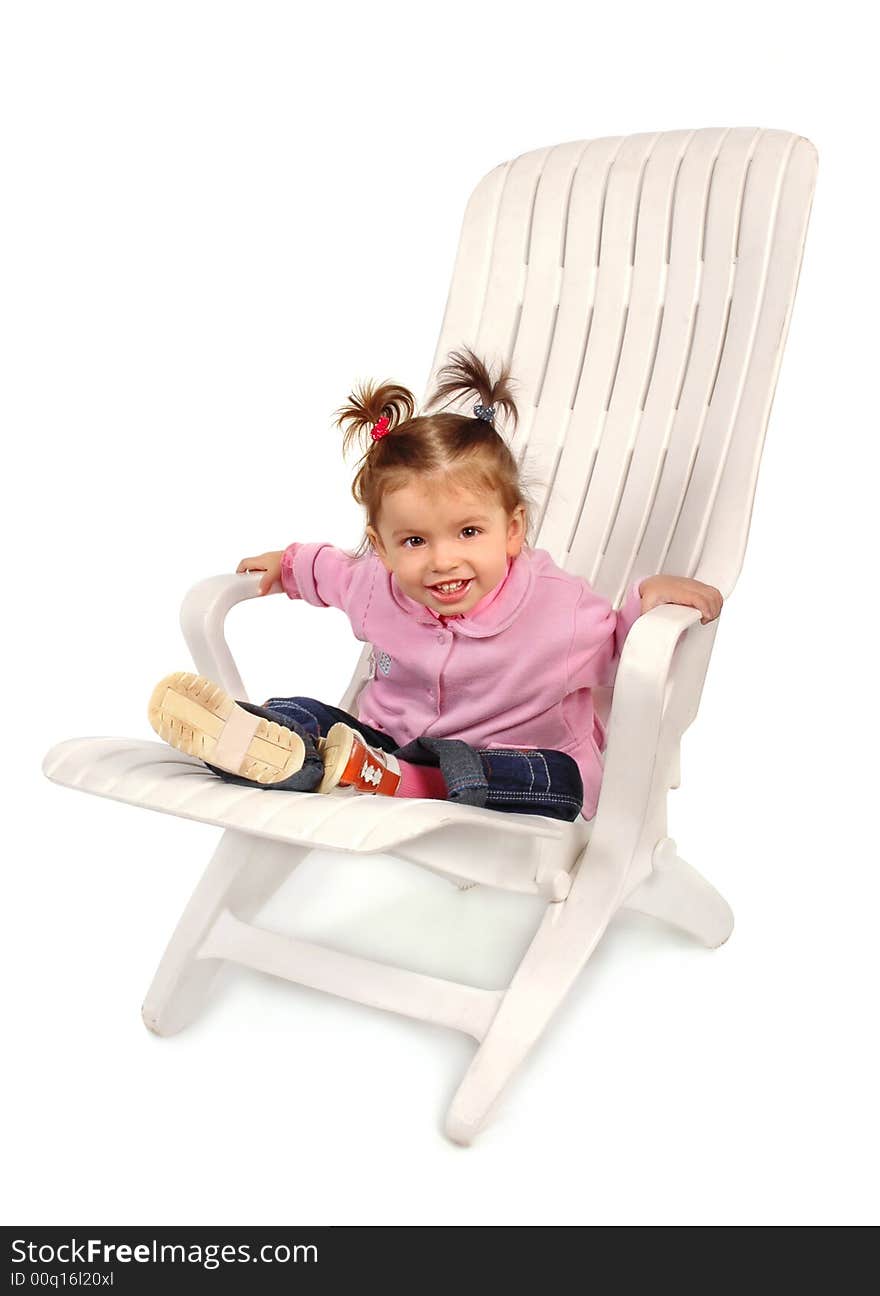 Small girl sitting on a chaise longue and smiling