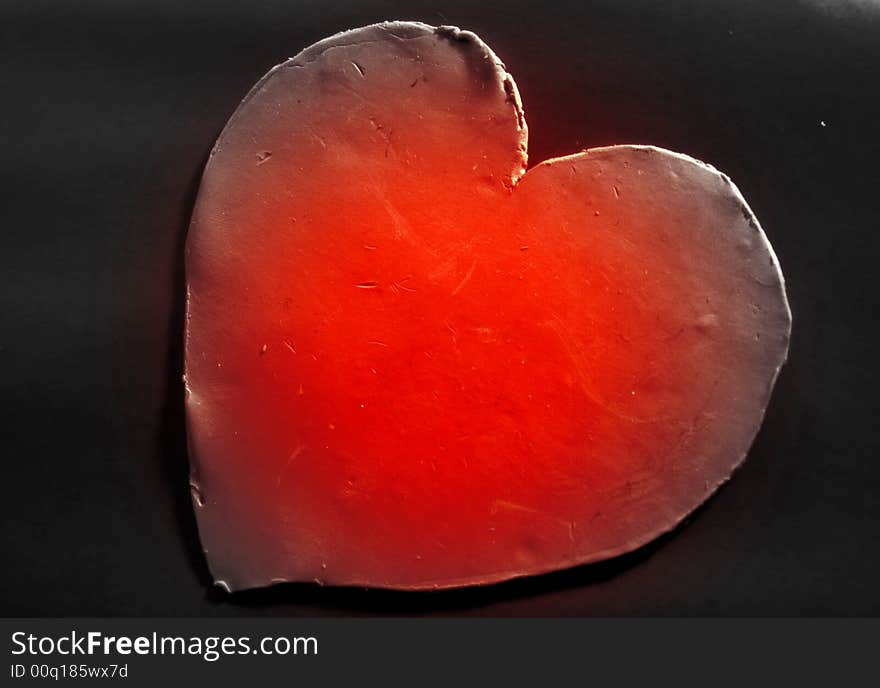 Red sculpted heart representing an inloved heart on black background. Red sculpted heart representing an inloved heart on black background