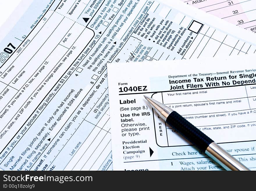 Image of 1040EZ IRS income tax forms with pen. Image of 1040EZ IRS income tax forms with pen