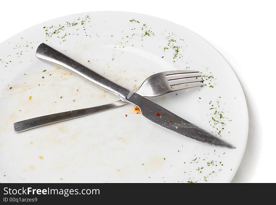 Unwashed fork and knife after eating lying on plate. Unwashed fork and knife after eating lying on plate