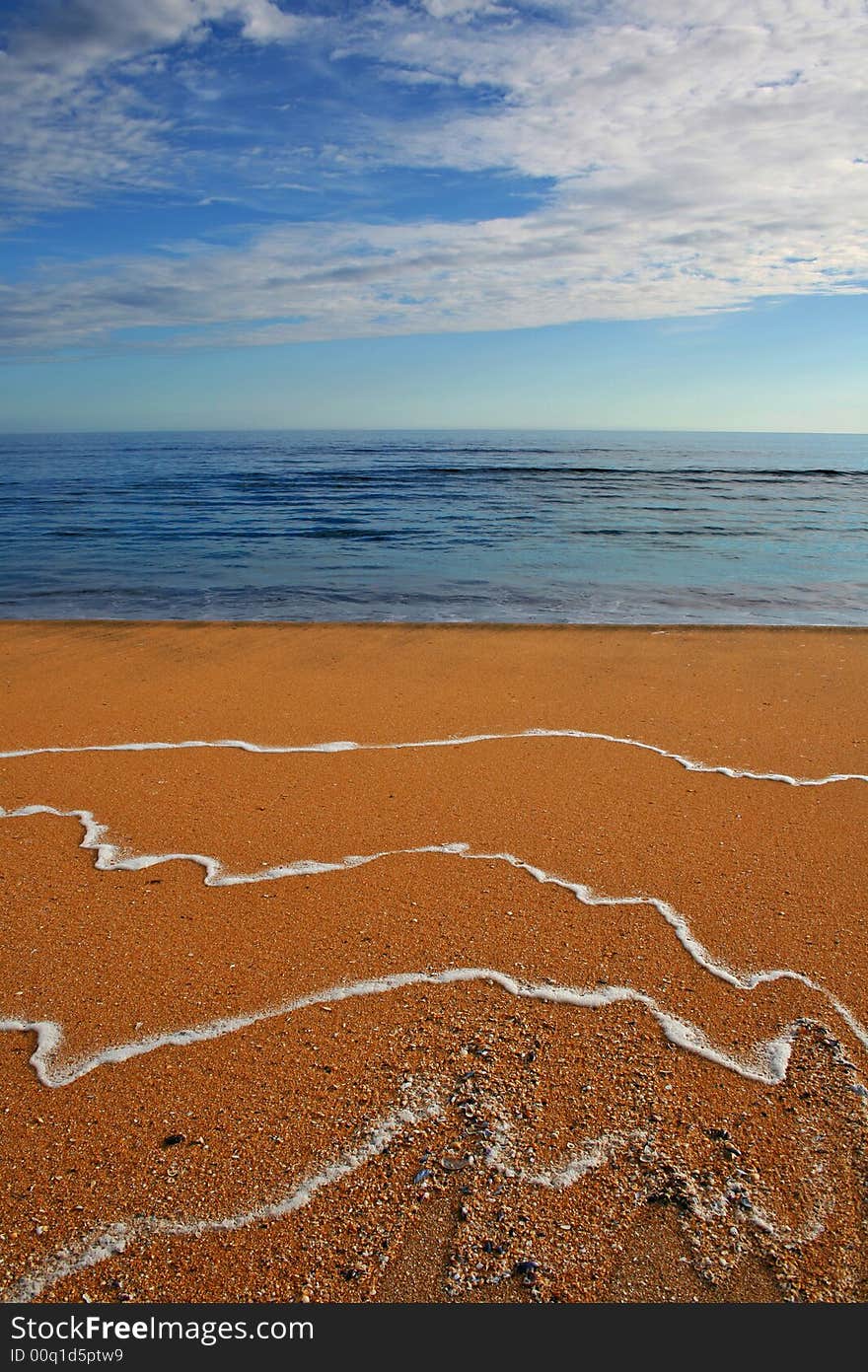 Orange sand beach and empty blue sea. Orange sand beach and empty blue sea.