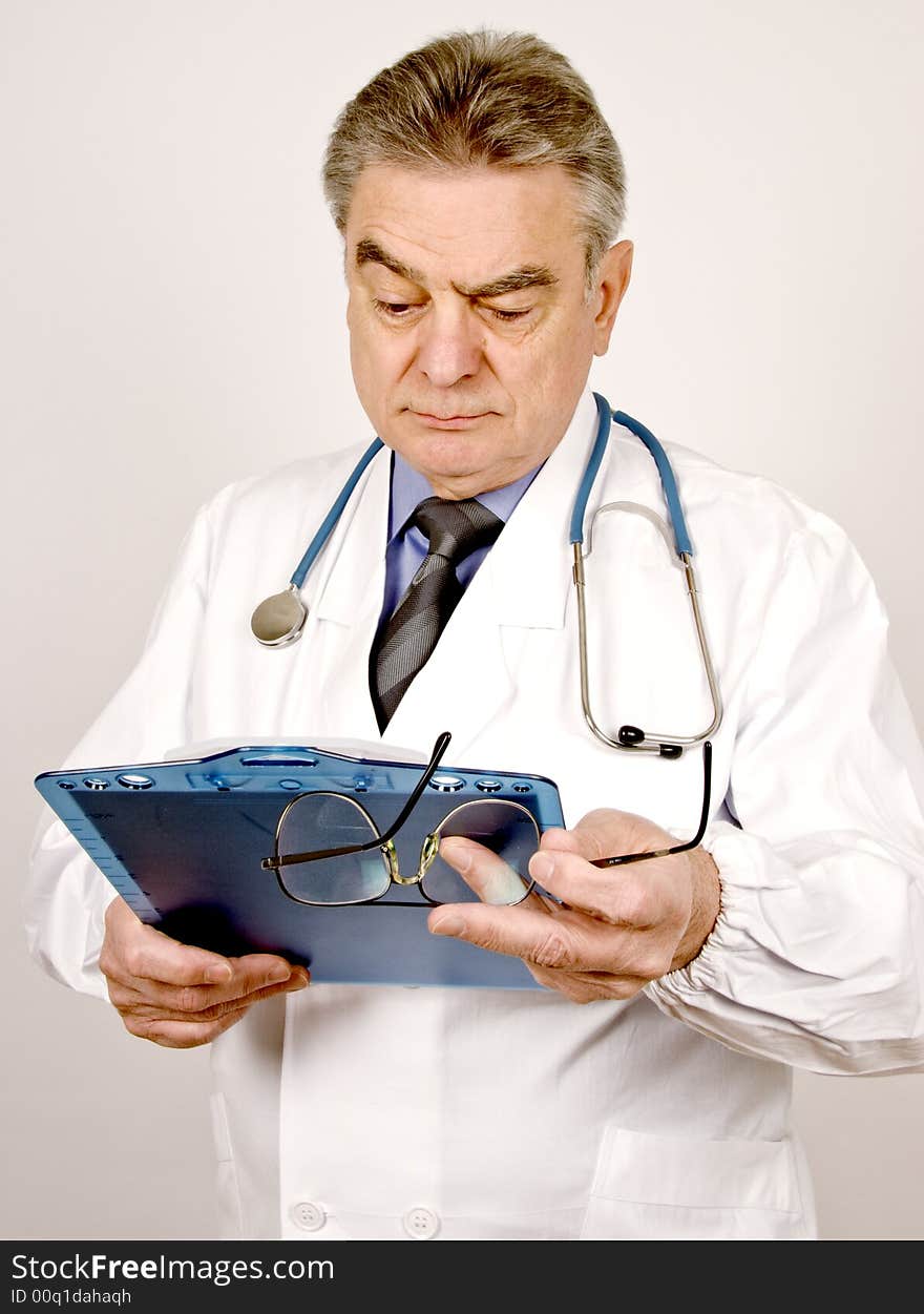 A mature male doctor looking at patient's chart.