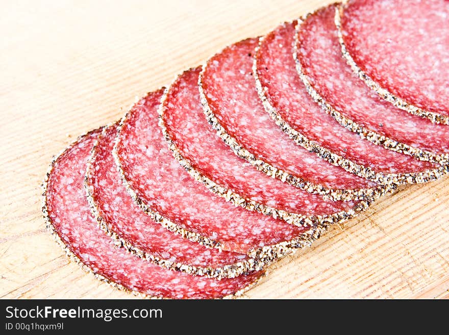 Peppered salami on a wooden chopping block