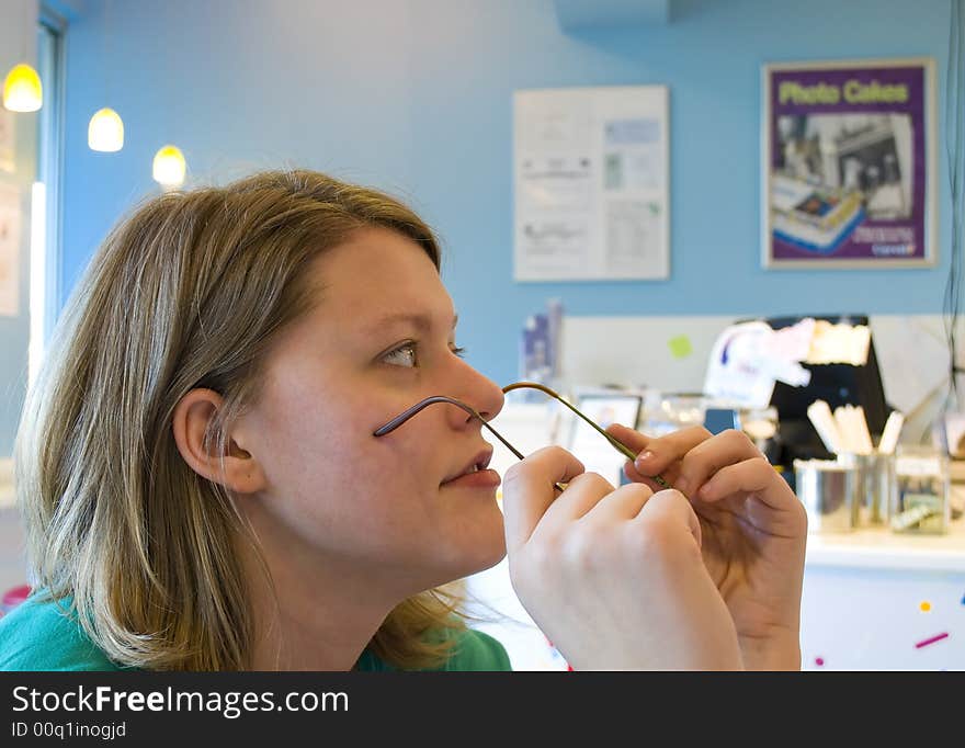 Picture of a woman taking off her glasses to take a closer look