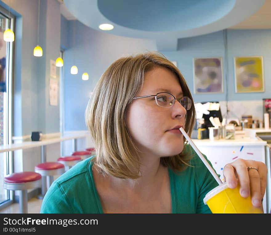 Picture of a woman drinking from a straw. Picture of a woman drinking from a straw