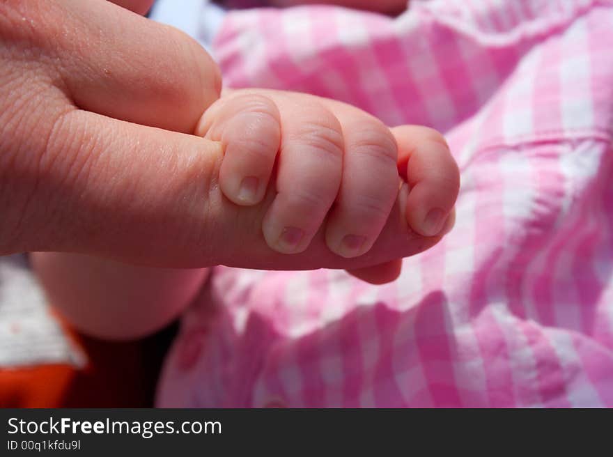 Newborn baby girl holding her father's finger. Newborn baby girl holding her father's finger