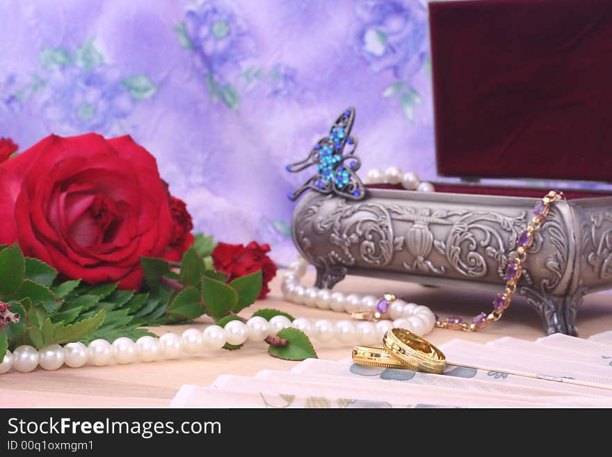 Roses With Pearls and Wedding Rings on Floral Background. Roses With Pearls and Wedding Rings on Floral Background