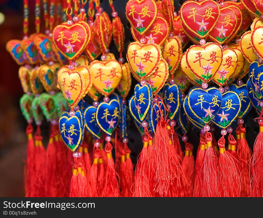 Hanging hearts ornaments in threes made of silk and embroidered with flowers and the Chinese characters, Ping An, meaning peace.