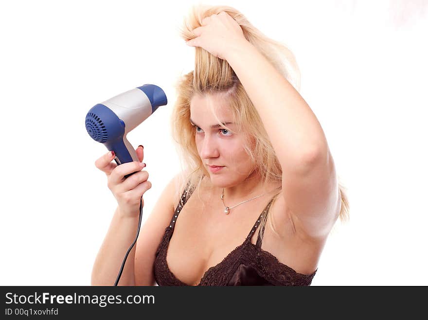 The young woman stacks hair by means of a hair drier. The young woman stacks hair by means of a hair drier