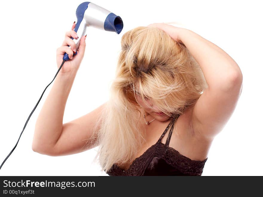 The young woman stacks hair by means of a hair drier. The young woman stacks hair by means of a hair drier