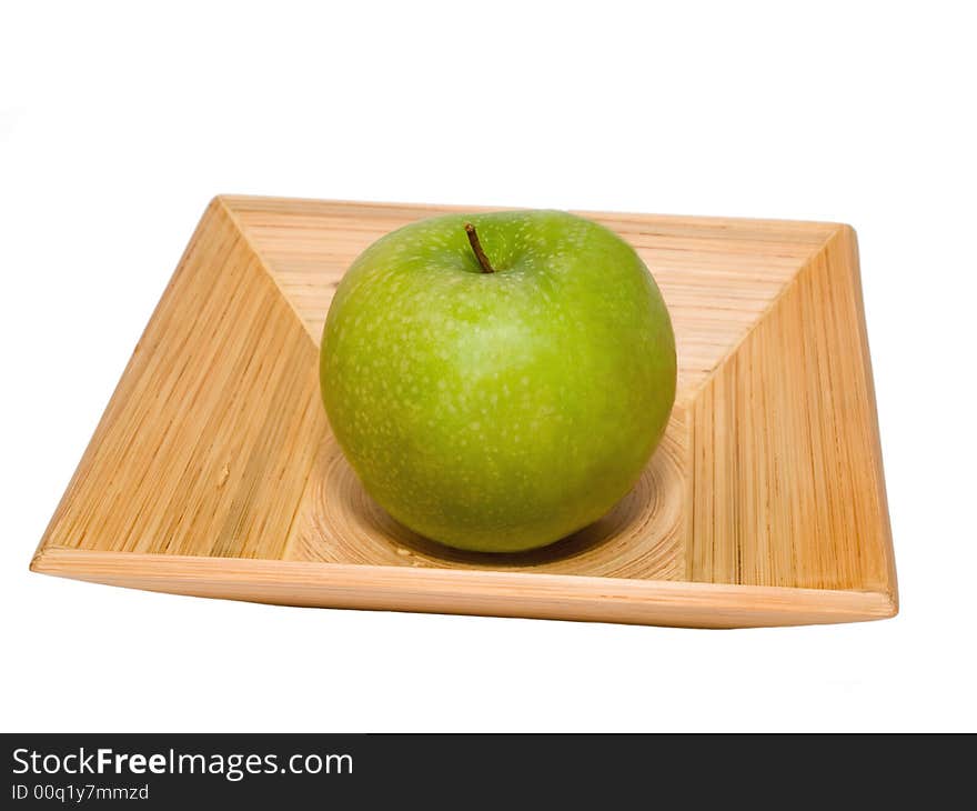 Fresh green apple on the pressed bamboo dish