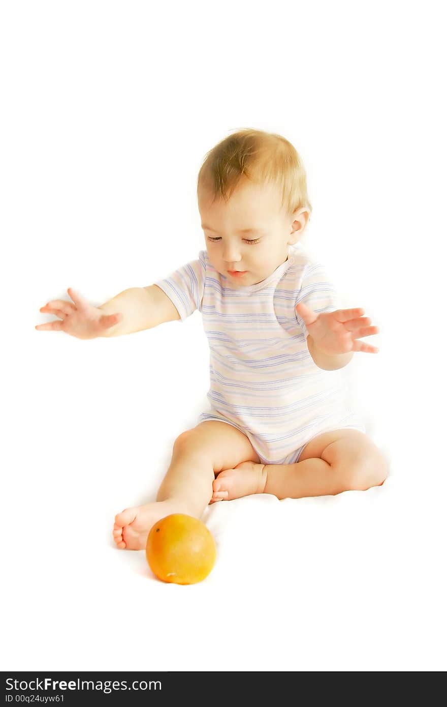 Baby tryinh to catch an orange over white