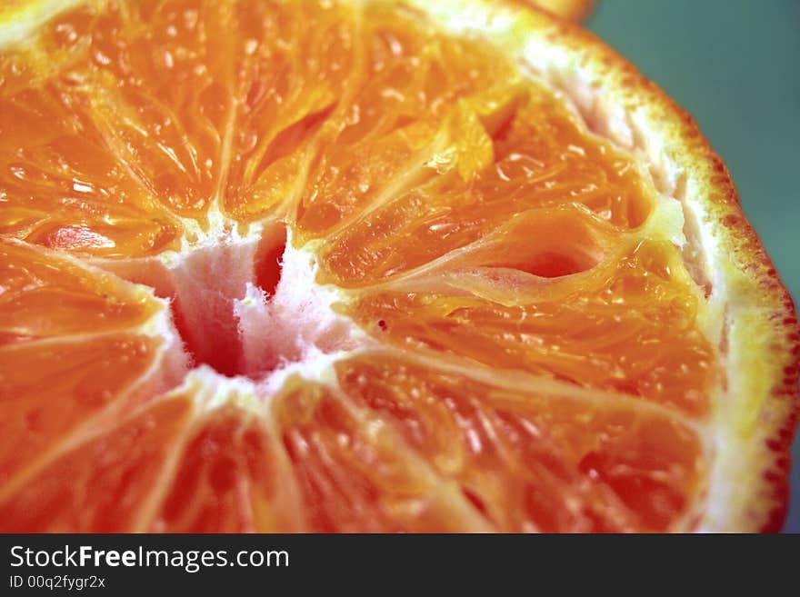 Half orange fruit close up on green background