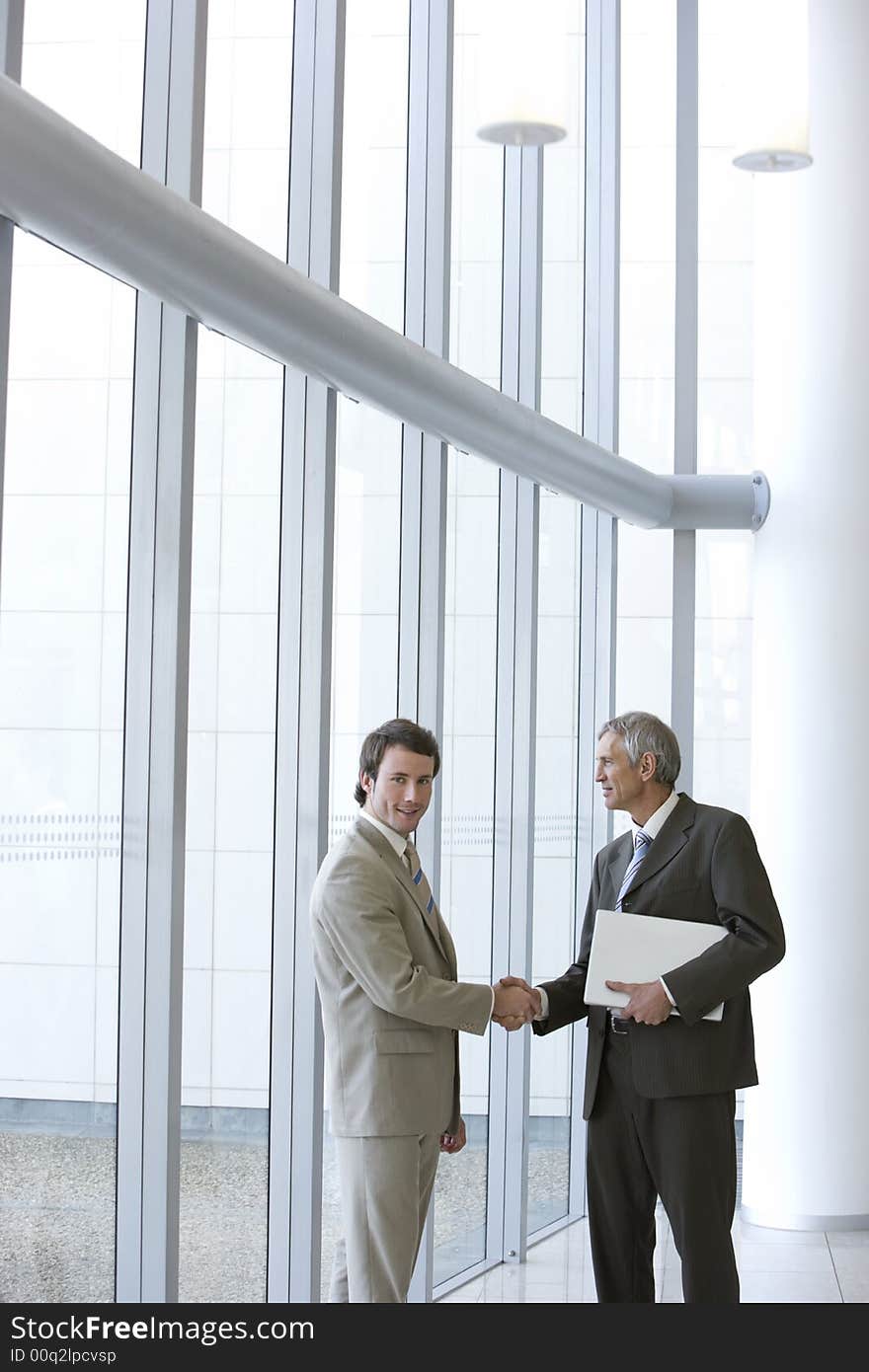 Shaking hands in front of windows