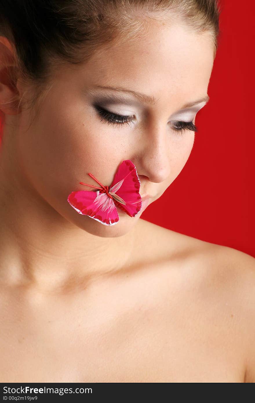 Beauty portrait of a beautiful young woman with a butterfly on her face. Beauty portrait of a beautiful young woman with a butterfly on her face