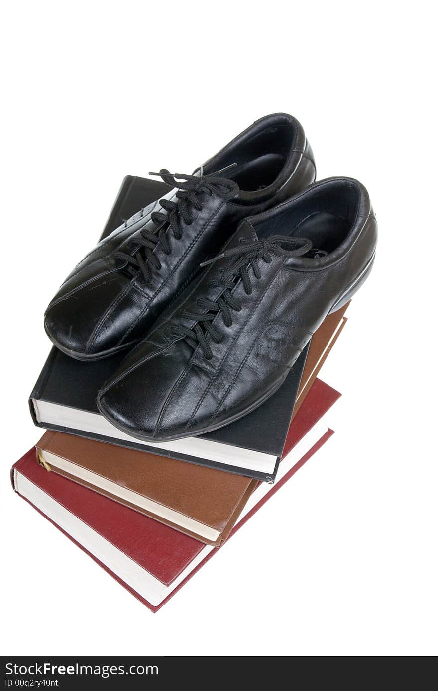 Man's shoes on books on a white background