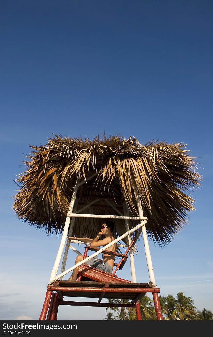 Young boy on a beach chair looking ahead and pointing