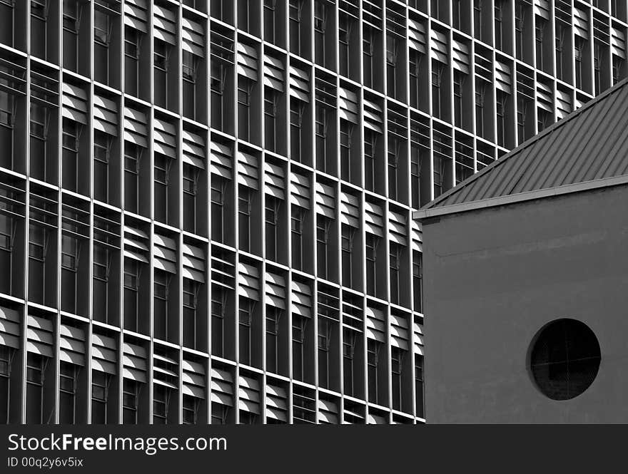 An abstract black and white image of a side of a building showing windows and shutters. An abstract black and white image of a side of a building showing windows and shutters