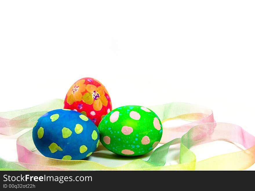 Three handpainted Easter eggs with ribbon on a white background. Three handpainted Easter eggs with ribbon on a white background.