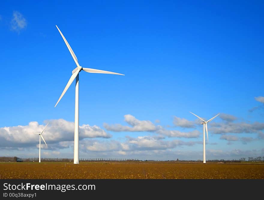 Wind Turbines in the field with blue cloudy sky