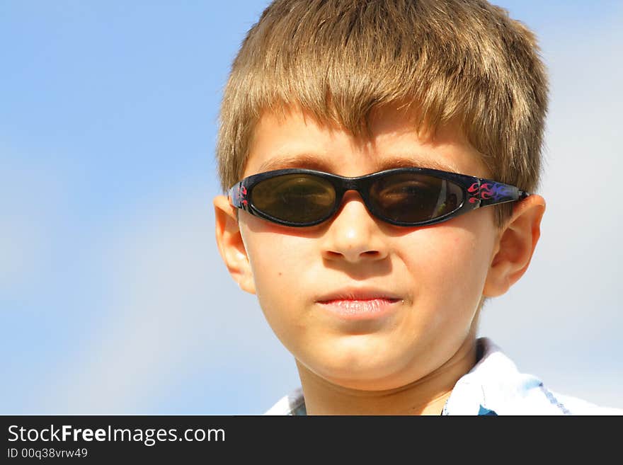 Boy with a smirk on his face and wearing sunglasses. Boy with a smirk on his face and wearing sunglasses