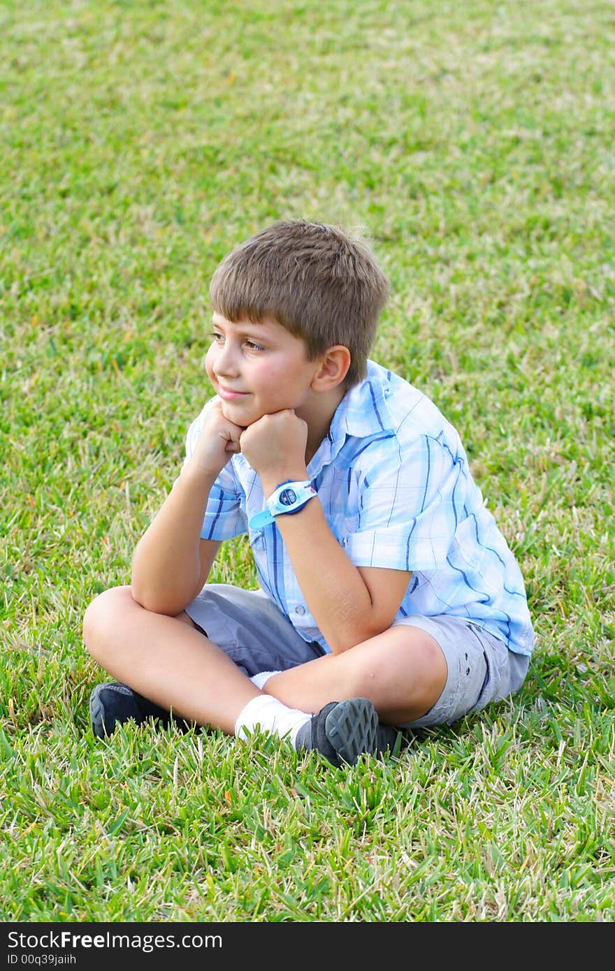 Boy sitting happily on the grass