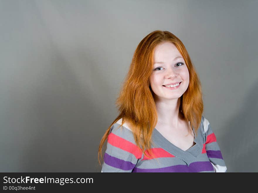 Portrait of young smiling woman on gray background