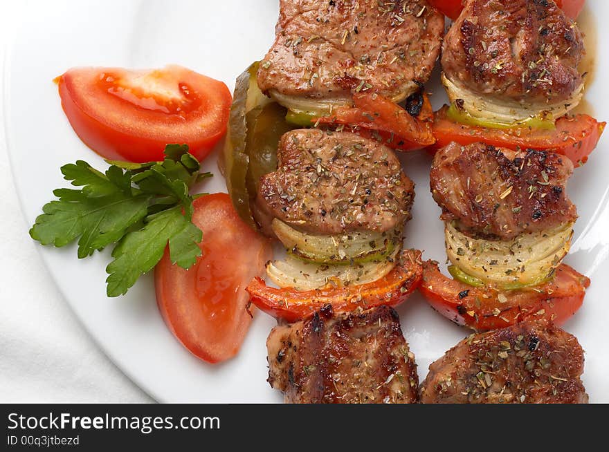 Kebab served with vegetables on white plate, closeup. Kebab served with vegetables on white plate, closeup