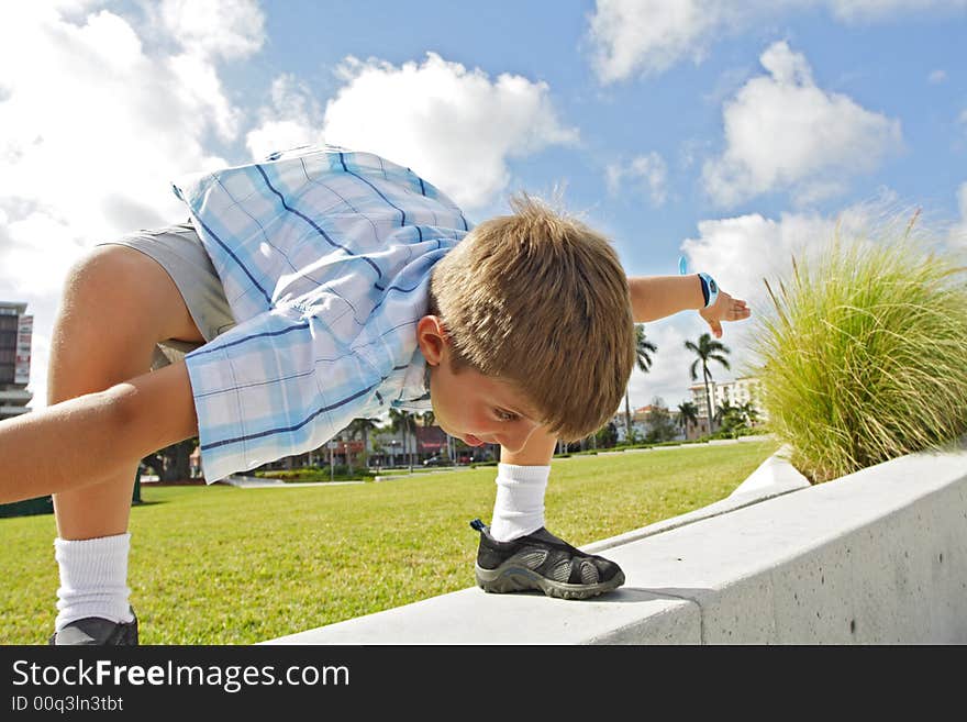 Boy crouching over on a ledge. Boy crouching over on a ledge