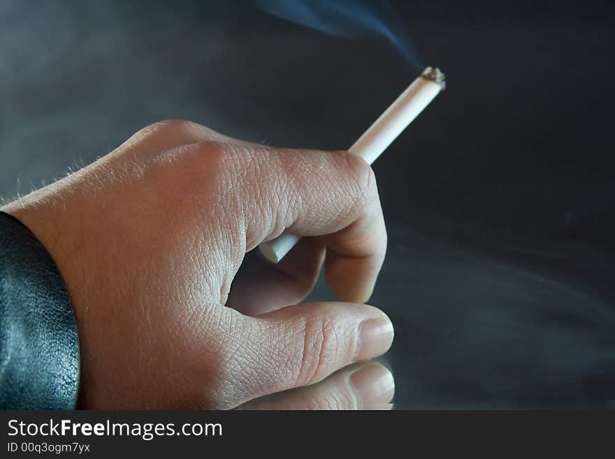 Human hand holding a cigarette. Human hand holding a cigarette