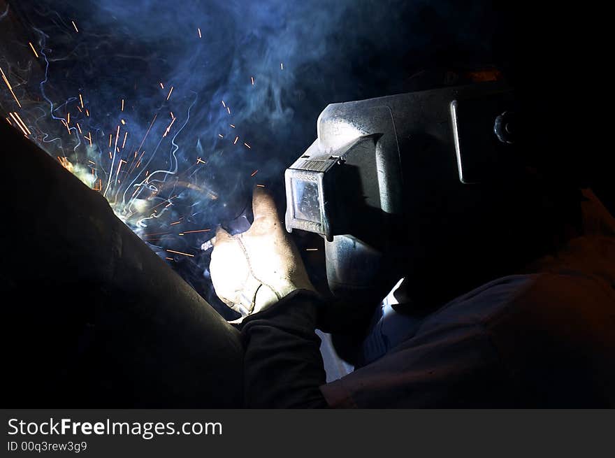 A welder working at shipyard at night. A welder working at shipyard at night