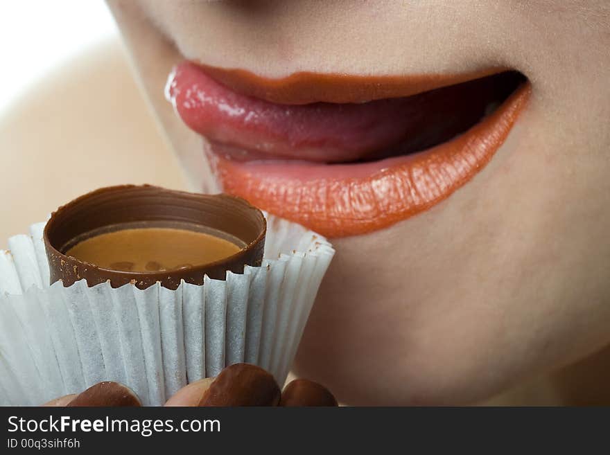 Woman lick lips with chocolate candy