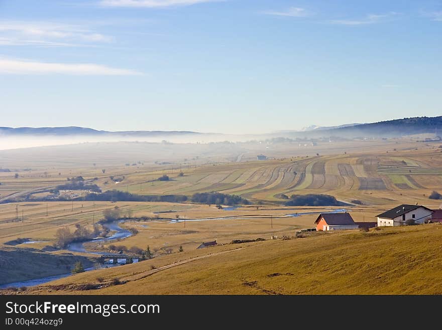 Landscape and river - green fields, the blue sky