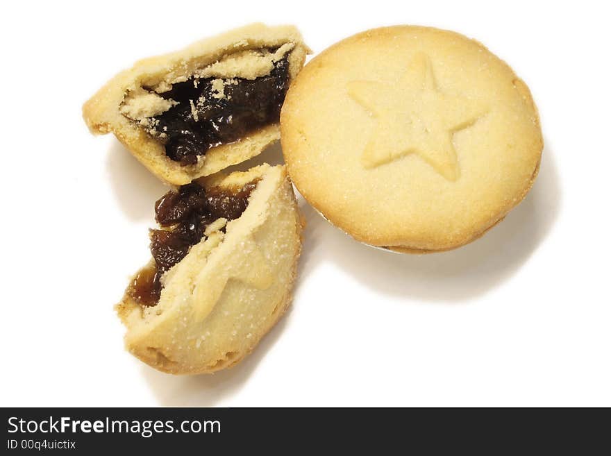 Two mincepies decorated with a star design one halved ready to eat isolated over a white background