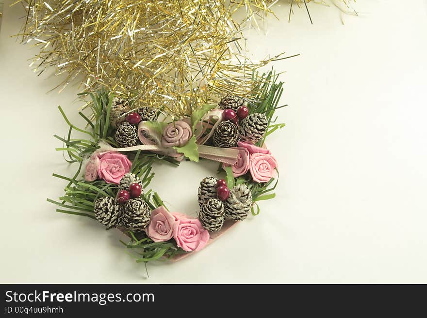 Gold and silver tinsel with heart shaped wreath and silver bells christmas tree decorations over a light background. Gold and silver tinsel with heart shaped wreath and silver bells christmas tree decorations over a light background
