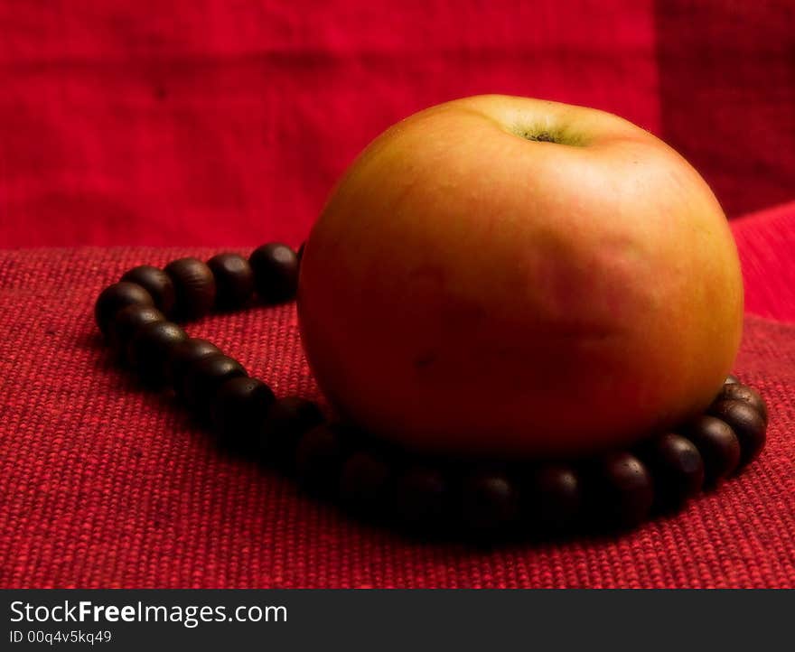 Single red apple background macro close up prayer beads. Single red apple background macro close up prayer beads