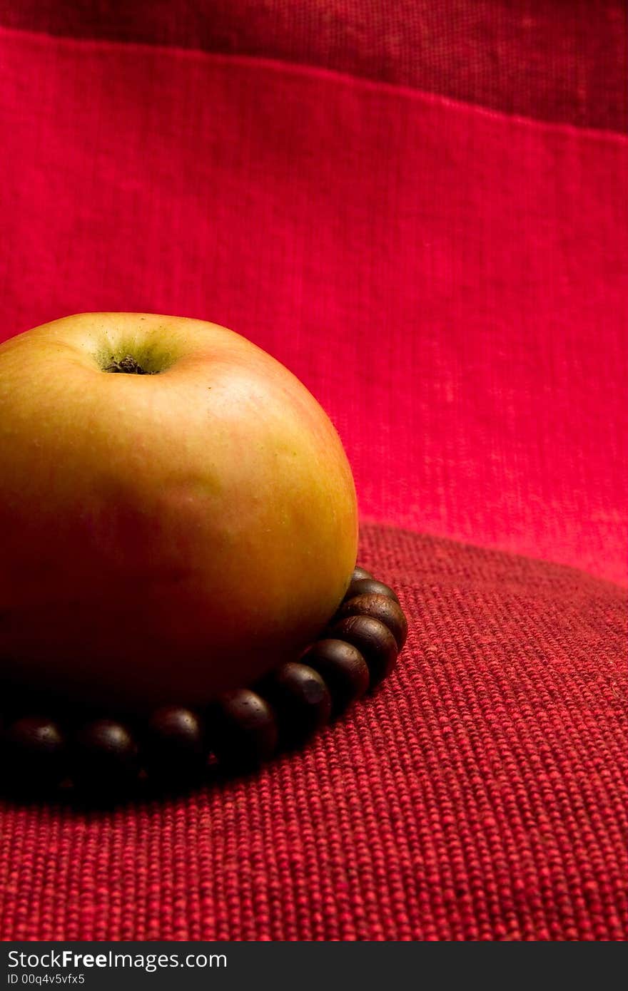 Single apple red background macro close up prayer beads. Single apple red background macro close up prayer beads