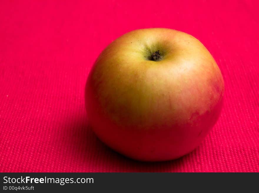 Single apple in red background close up macro studio. Single apple in red background close up macro studio
