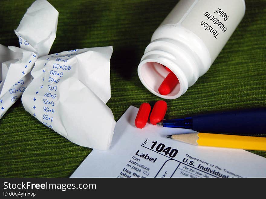 Bottle of aspirins and a 1040 tax form. Bottle of aspirins and a 1040 tax form.