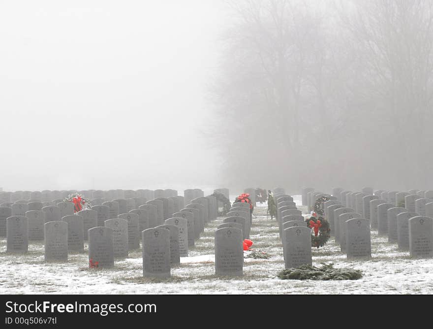 The headstones in a military cemetery on a foggy winter's morning. The headstones in a military cemetery on a foggy winter's morning