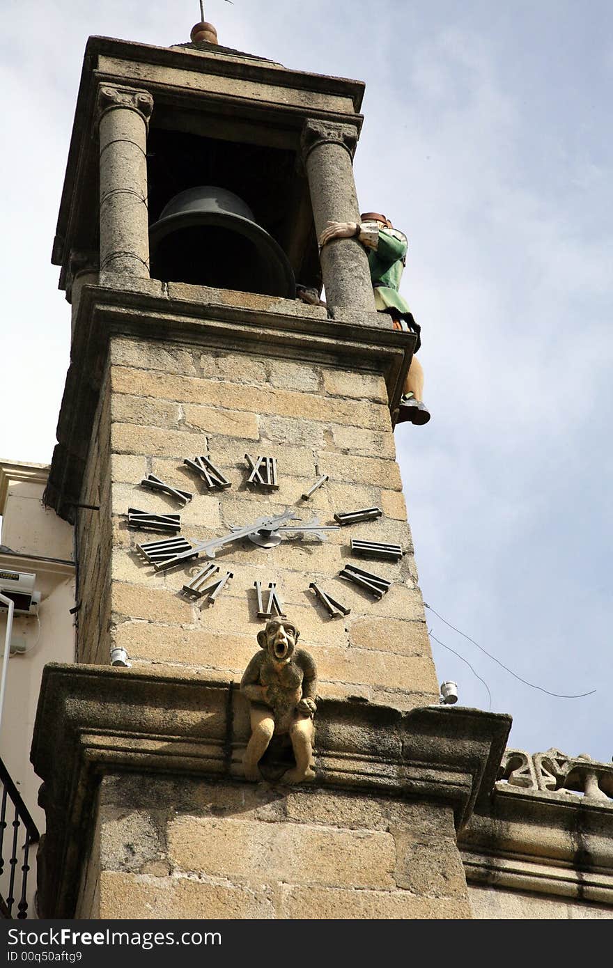 Spanish bell tower with a statue screaming and a puppet hitting bell. Spanish bell tower with a statue screaming and a puppet hitting bell