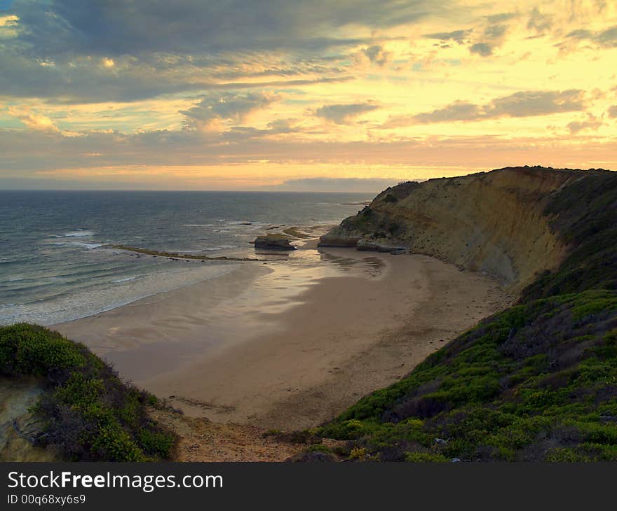 The Australian coastline stretching far with a sunset in the background. The Australian coastline stretching far with a sunset in the background.