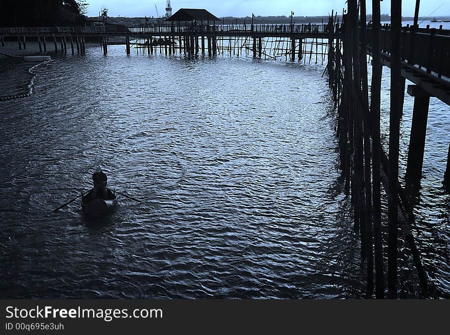 A fisherman rowing his boat after a hard day's work. A fisherman rowing his boat after a hard day's work